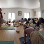 Sala branca de piso de madeira; a turma em postura de pé