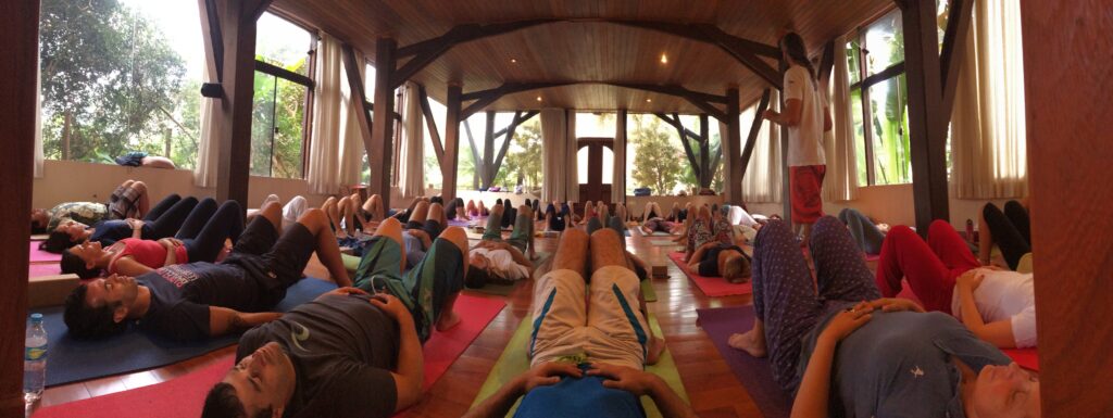Grande sala de madeira, com a turma deitada em descanso profundo