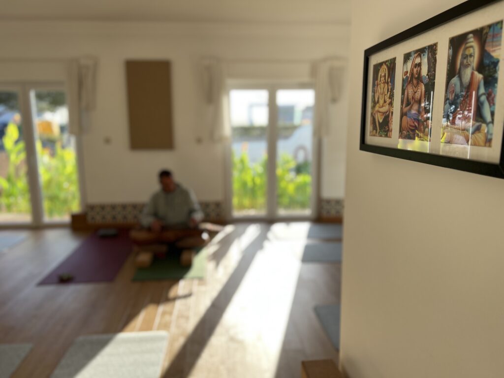 Sala banhada de luz; alguém sentado em meditação.