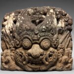 Escultura de pedra vulcânica (Índia, séc. XII–XIV): A Face do Tempo (Kāla-mukha)