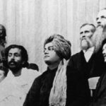 Fotografia de 1893: Swāmi Vivekānanda, de turbante, sentado ao centro entre outros delegados no Parlamento Mundial das Religiões, em Chicago
